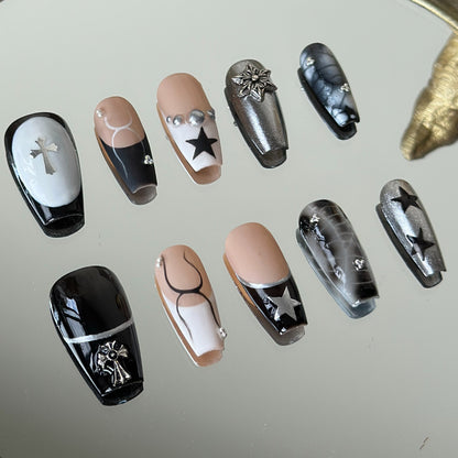 Detailed left side view of Crux press-on nails highlighting the intricate silver 3D cross charm and smoky black marble nail art.