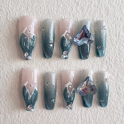 MYOB Nails handcrafted press-on nails with deep blue cat eye gradient effect, featuring shimmering magnetic light, flowing white line art, and a luxury 3D blue heart crystal gem.