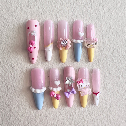 MYOB Nails vibrant dopamine-style press-on nails in pastel pink, yellow, and blue, featuring 3D ice cream cone designs, cute cartoon cat charms, pink bows, and heart accents.