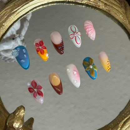 MYOB Nails Ethereal Bloom almond press-on nails, left angle laid atop vintage mirror, showcases sculpted floral depth, nail thickness and handcrafted dimensional flower textures