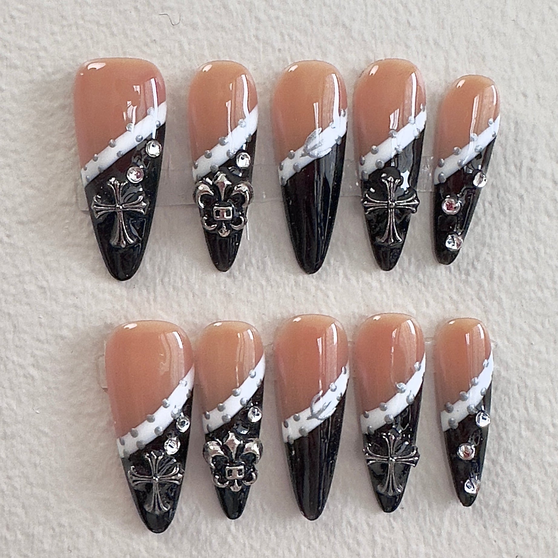 Nude and black gothic French tip nails with silver cross charms by MYOB Nails.