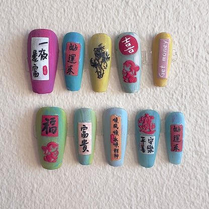 Handmade press-on nails by MYOB Nails featuring traditional Chinese calligraphy characters for wealth and luck, hand-painted floral art, and vibrant symbolic colors