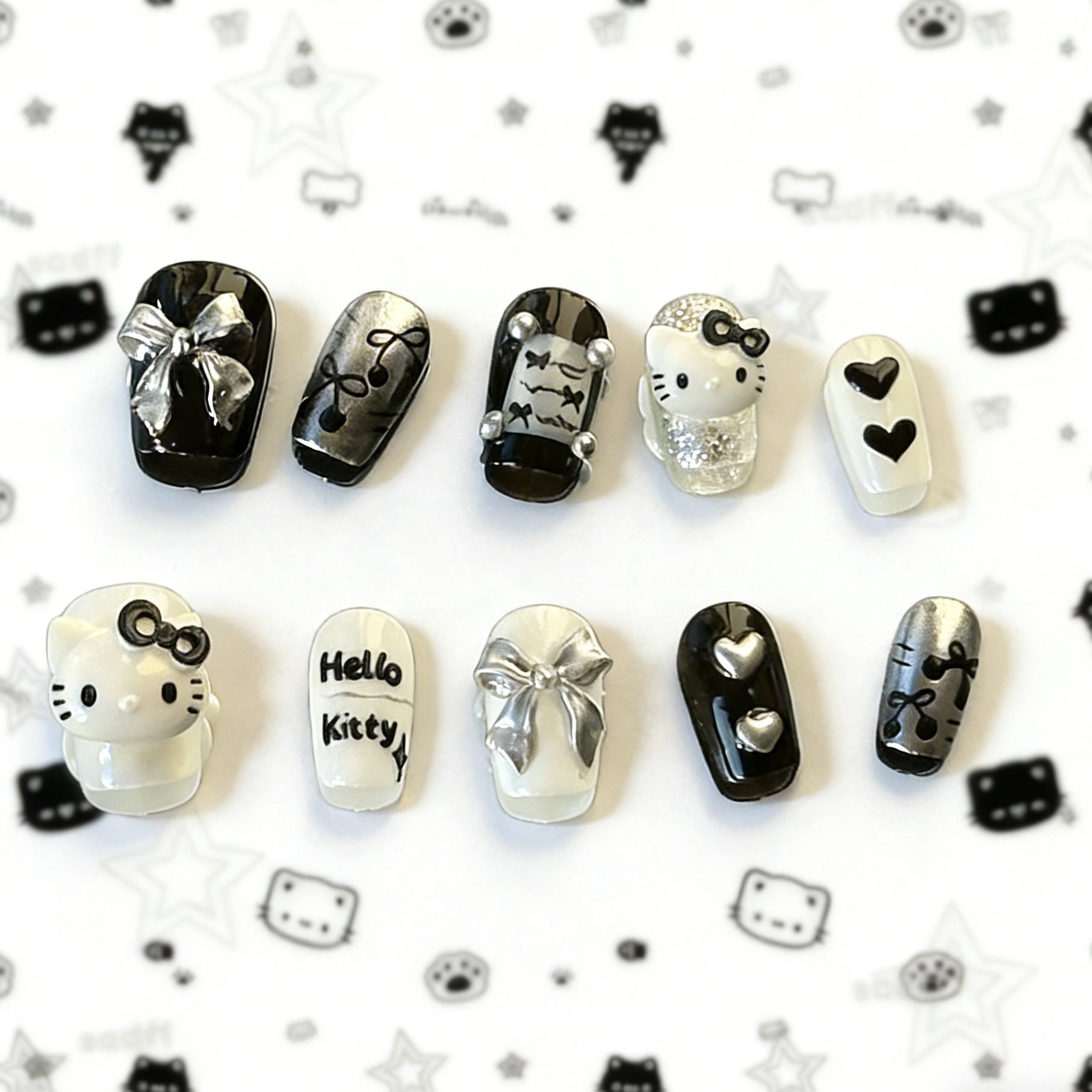 MYOB Nails Y2K style black and white press-on nails featuring 3D kawaii cat charms, silver bows, and heart accents.