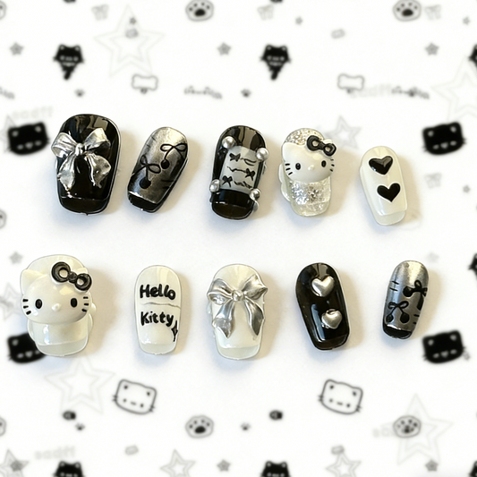 MYOB Nails Y2K style black and white press-on nails featuring 3D kawaii cat charms, silver bows, and heart accents.