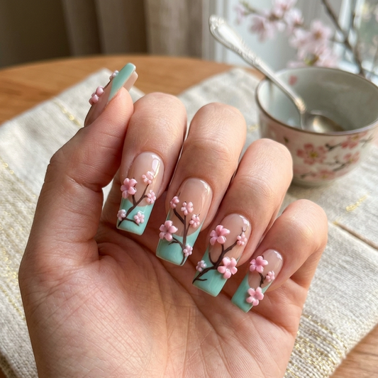 MYOB Nails Zen Blossom collection featuring mint green French tips with 3D pink cherry blossoms on a hand model, styled with vintage tea sets and cherry blossom branches.