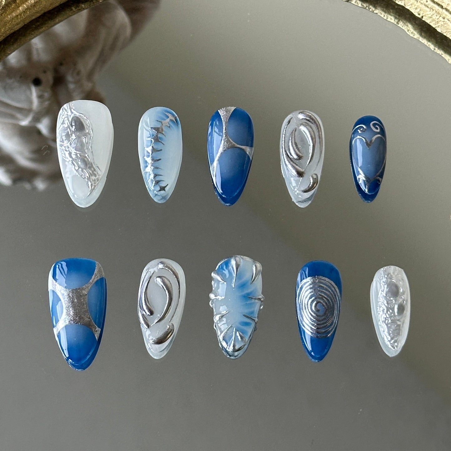 Front view of Nerion nails showcasing the ethereal sea-foam marble and 3D silver metallic accents.