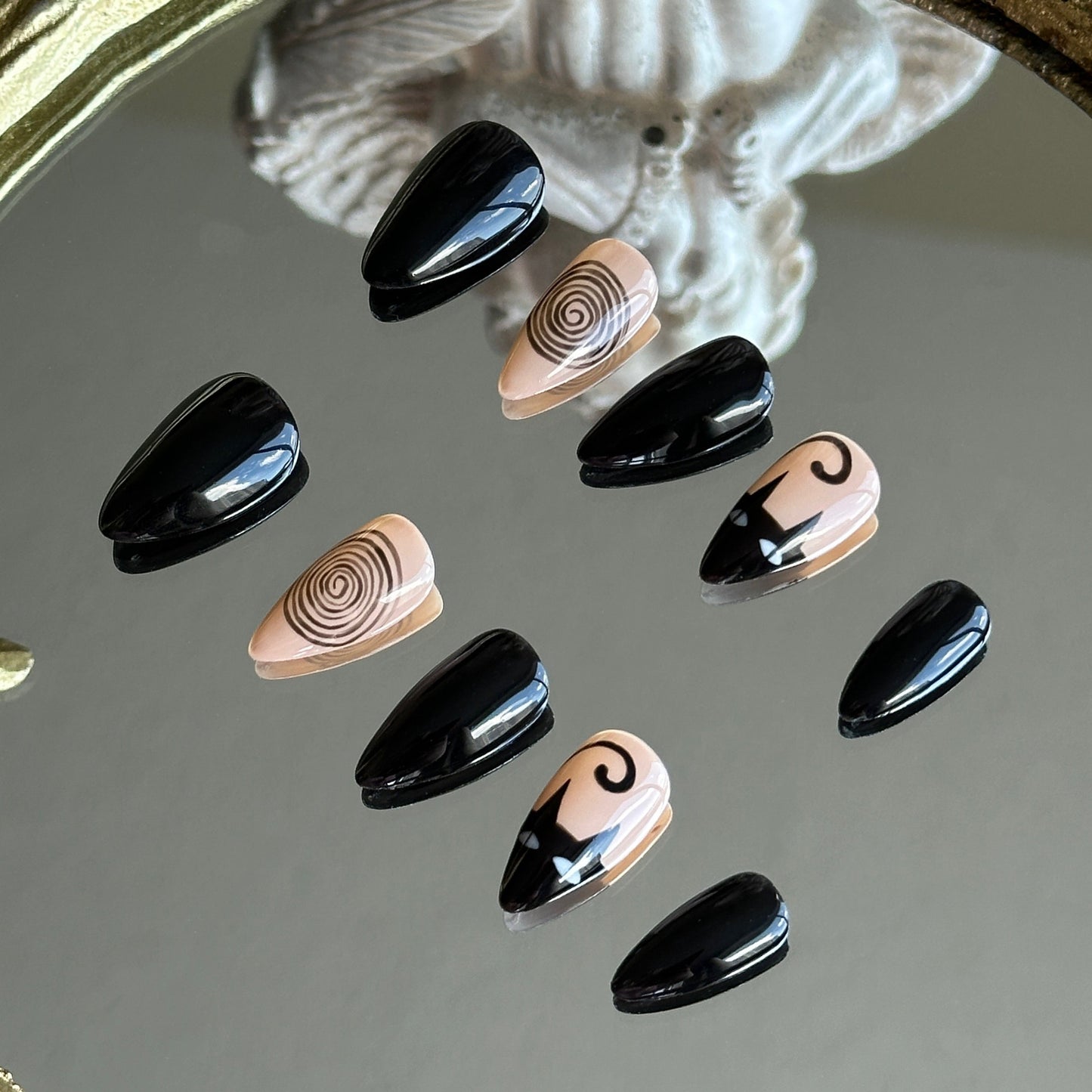 Right side view of Noir Whimsy nails by MYOB Nails showing the sharp, abstract black swirl patterns and glossy stiletto finish.