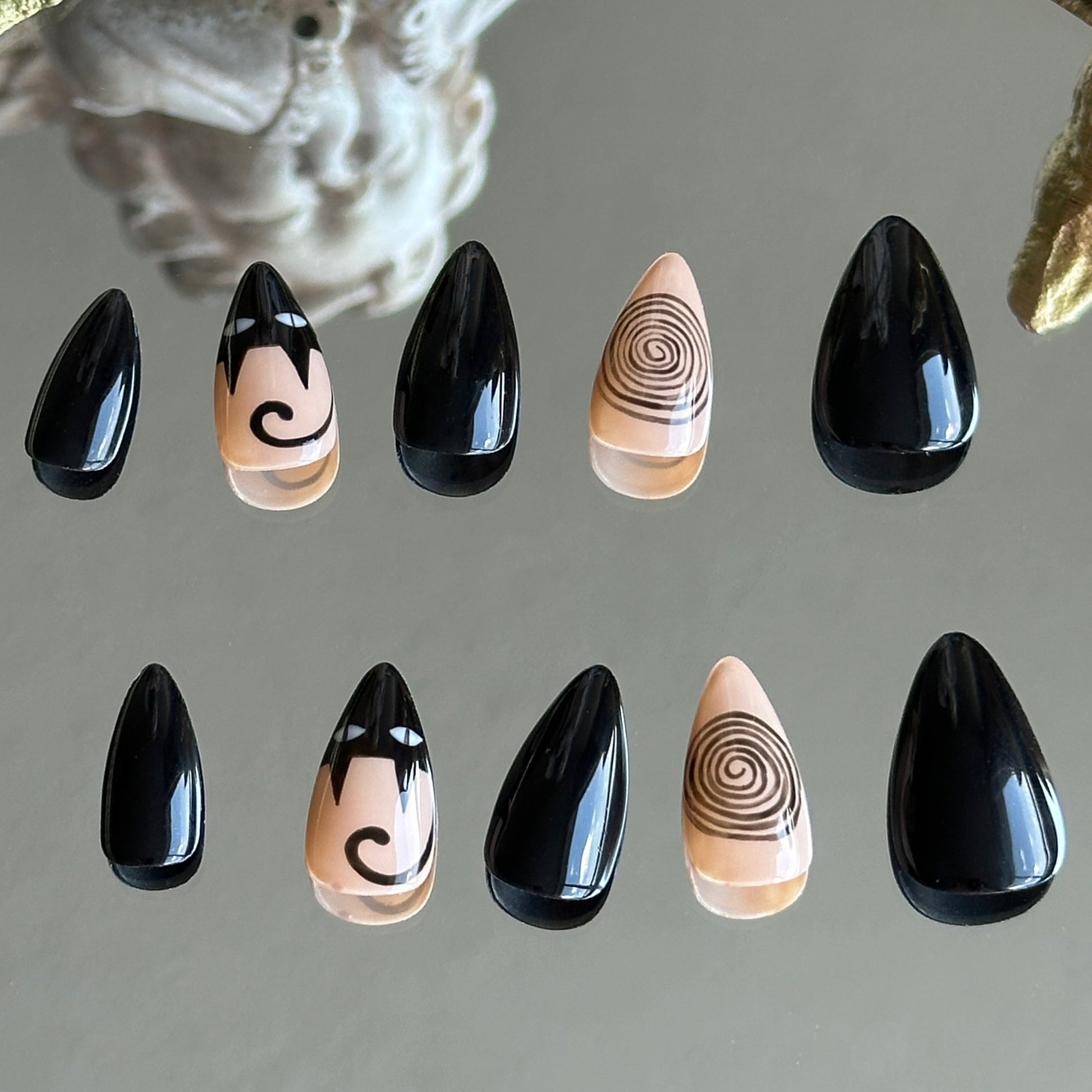 Back view of the Noir Whimsy handcrafted nail set by MYOB Nails, showcasing a minimalist yet whimsical black and beige aesthetic.