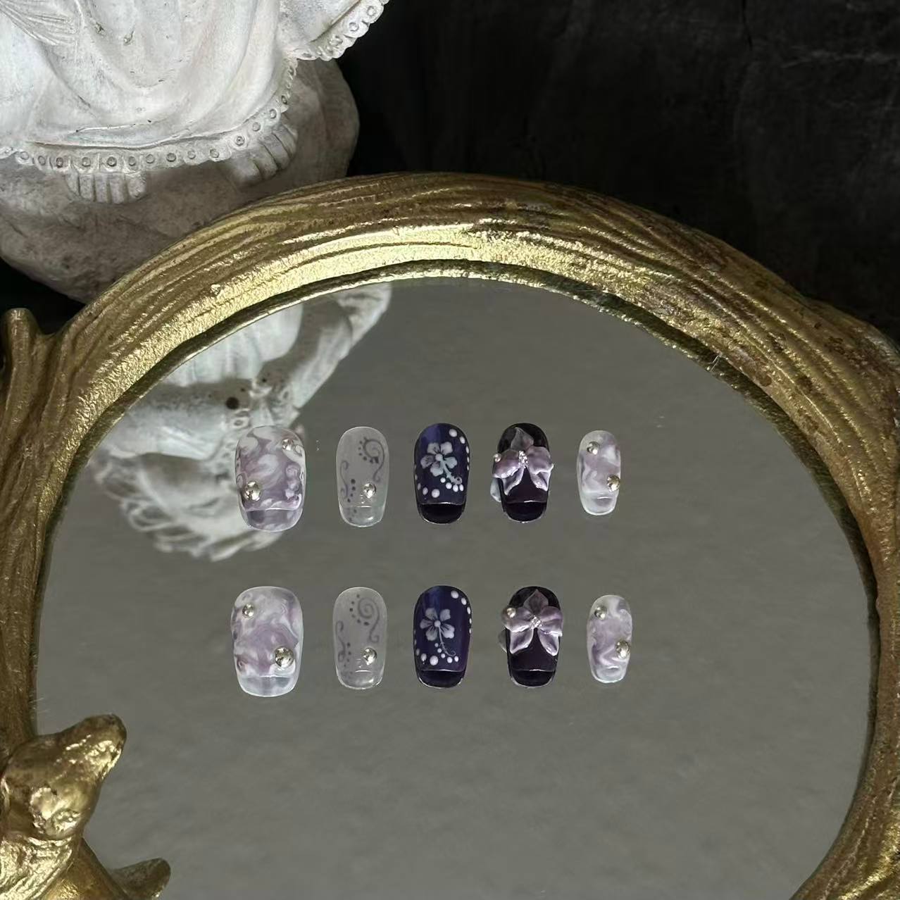 Front view of Orchid Mirage nails showing the blend of iridescent purple aurora powder, silver cat-eye, and marble swirl patterns.