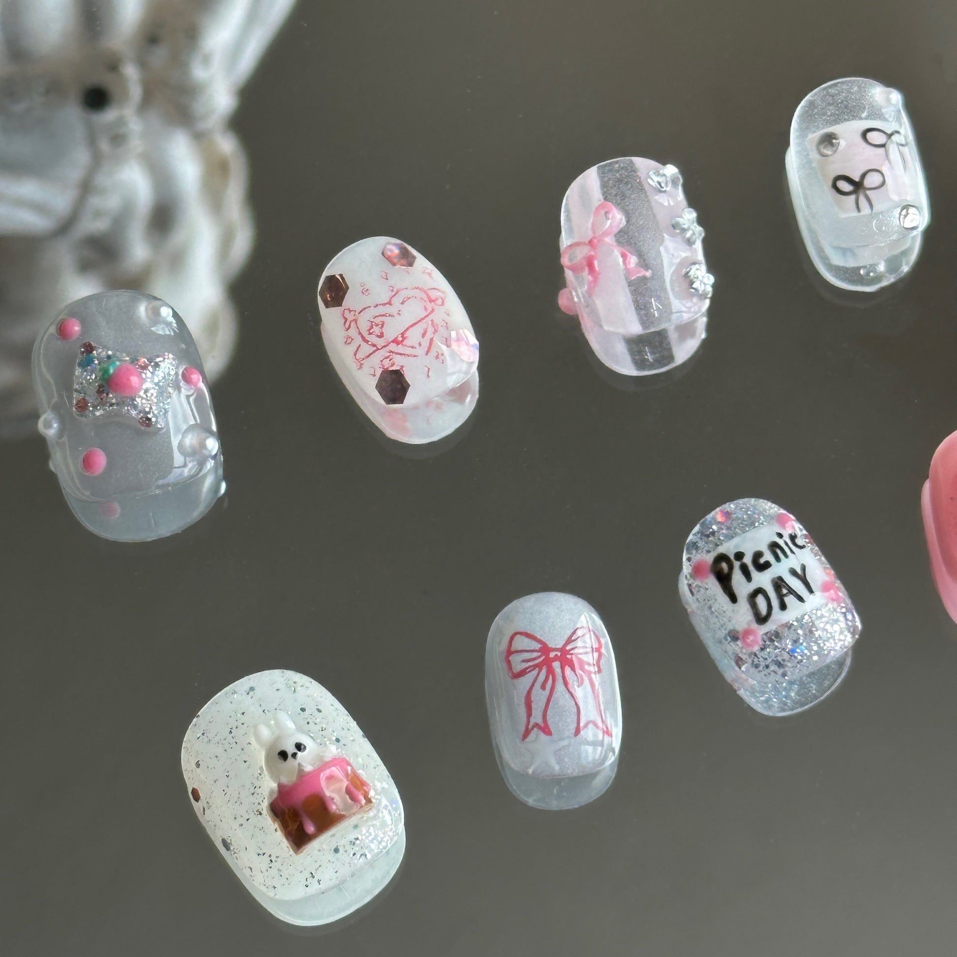 Left side detail highlighting the sculpted 3D bunny cake, tiny pink fork, and spoon charms by MYOB Nails.