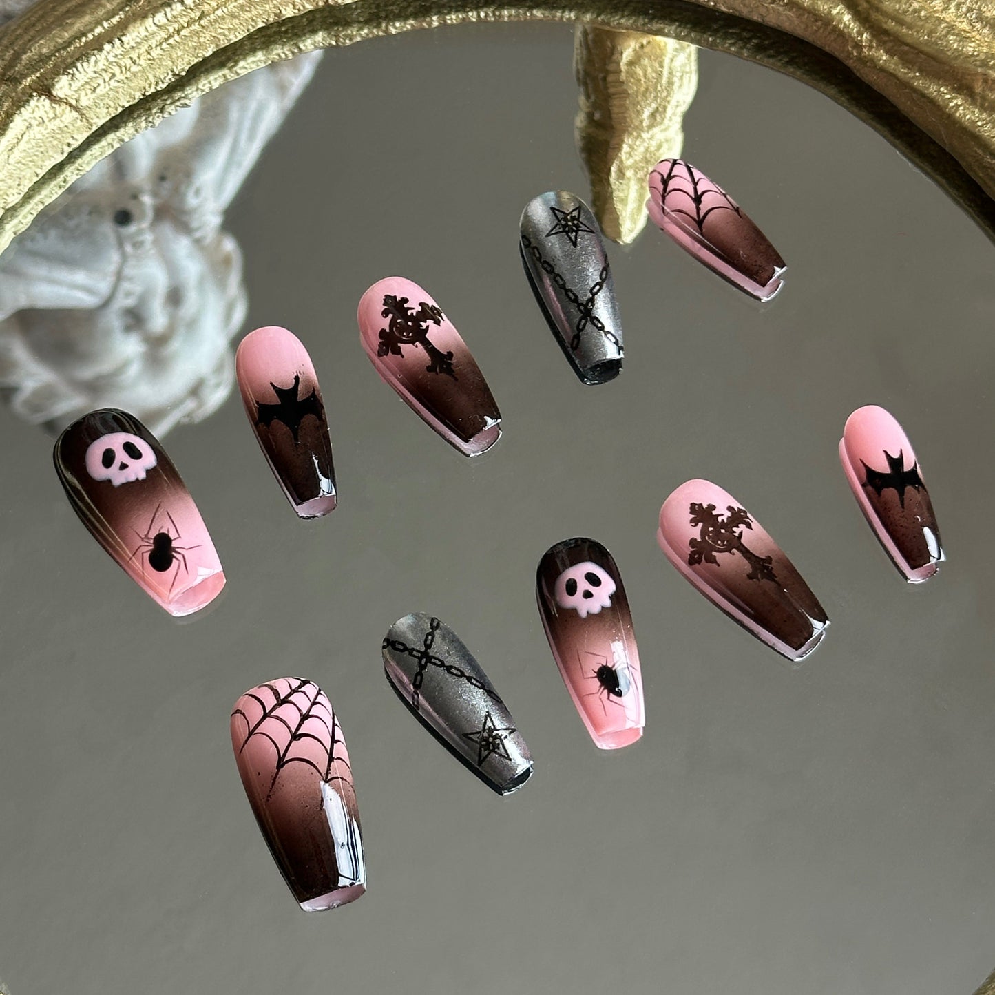 Left side detail of MYOB Nails Pink Abyss set highlighting the hand-painted pink skull and intricate black spiderweb motifs.