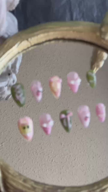 A cinematic close-up video of Tiana press-on nails by MYOB Nails, showcasing the 3D pink ribbon bows, forest green finish, and corset-inspired art in motion.