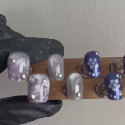 A dynamic hand-held video of MYOB Nails' Orchid Mirage, showcasing how the brilliant silver cat-eye and deep violet aurora shimmers shift under different light angles.
