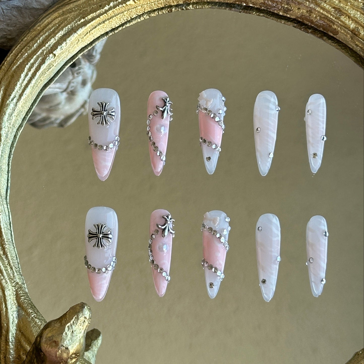 Front view of Princess Rebel handmade press-on nails by MYOB Nails featuring pink and white marble base with silver crosses and chain accents.