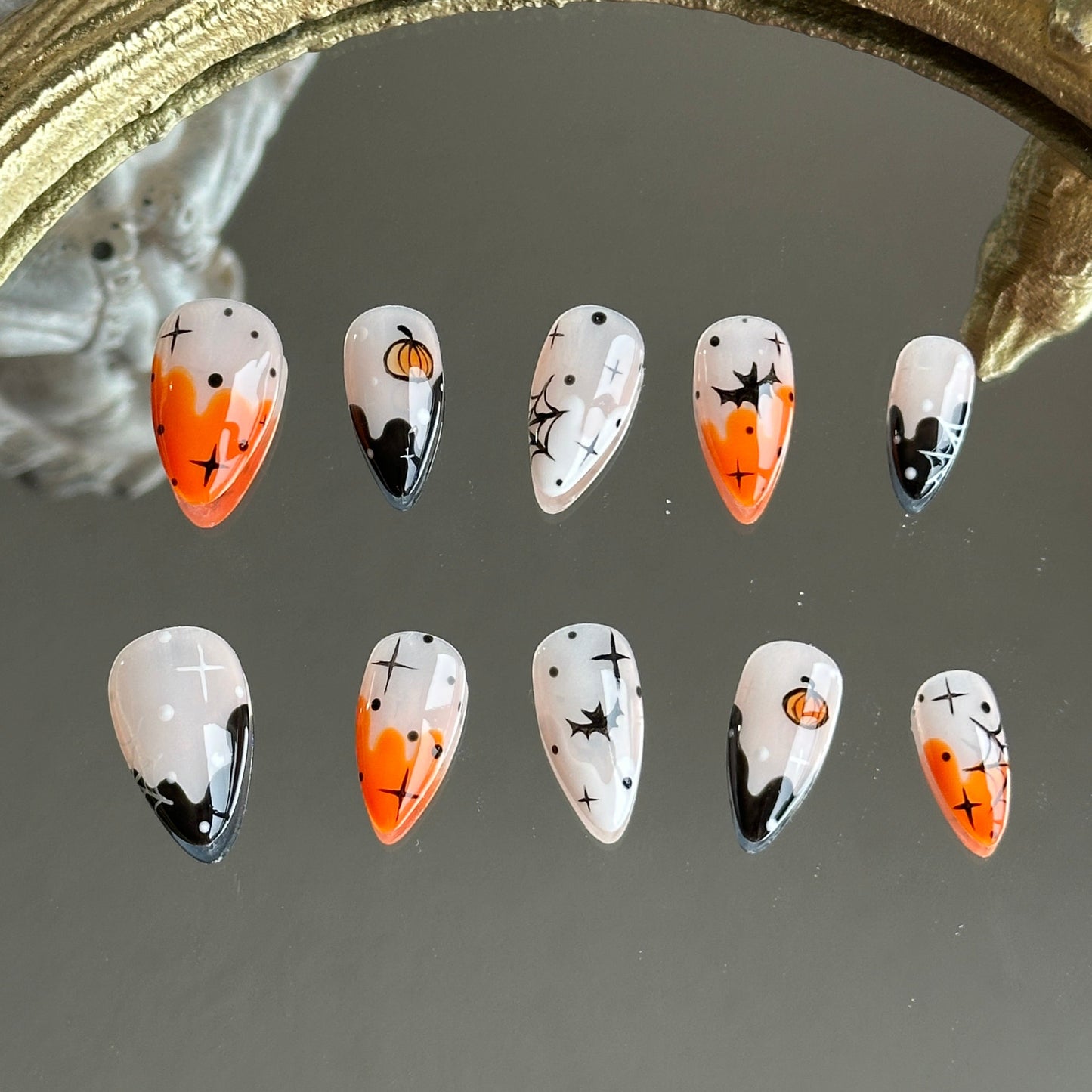 Front view of Pumpkin Spell handmade press-on nails by MYOB Nails featuring orange and black ombre with hand-painted pumpkins and bats.