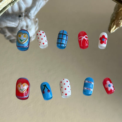 Front view of Retro Bloom handmade nails by MYOB Nails showcasing red and white checkerboard tips with vibrant blue accents.