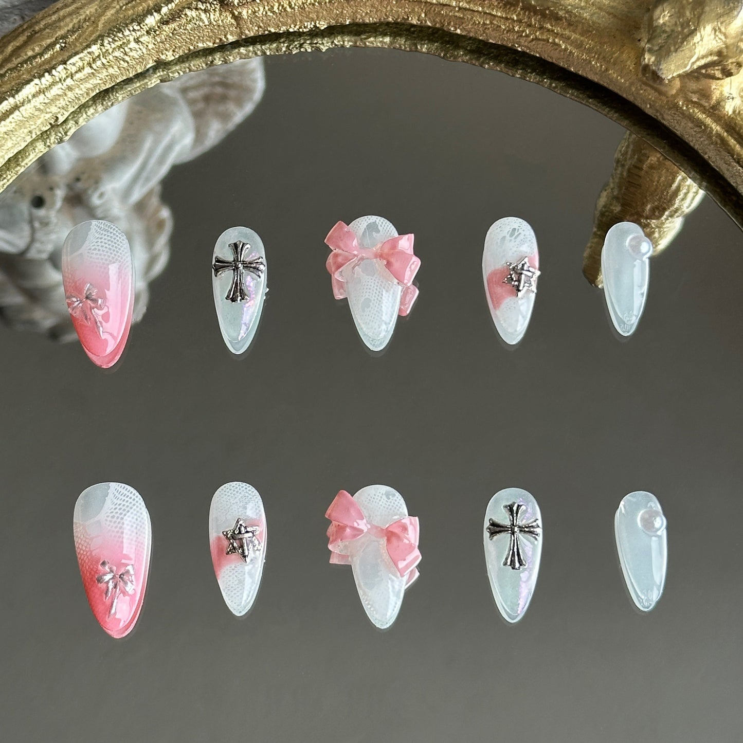 Front view of Sacred Blush handmade press-on nails by MYOB Nails featuring pink ombre, chrome crosses, and 3D bows.