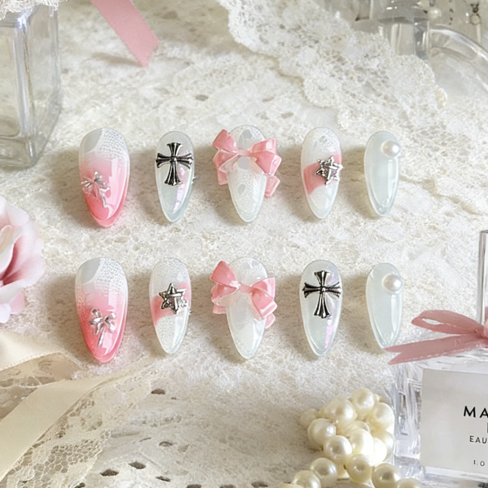 Sacred Blush press-on nails by MYOB Nails presented on a delicate white lace background with a luxury perfume bottle.