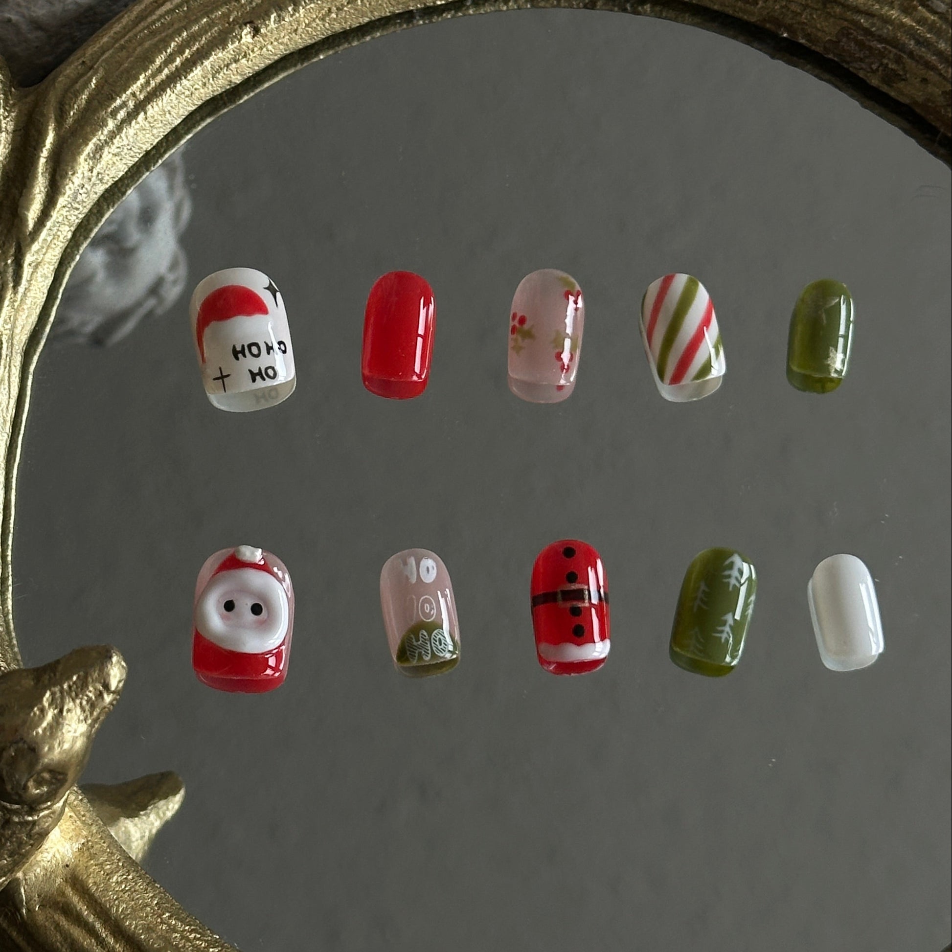 christmas nail with 3d santa and handpainted festival details. featured in green, blue and nude colors.