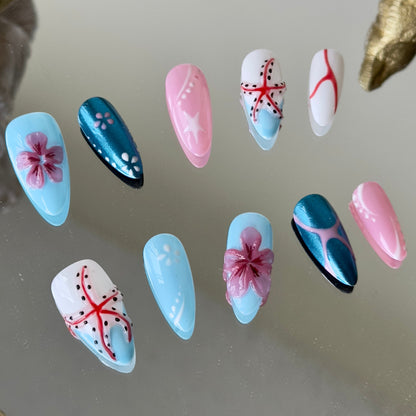 Close-up of the handcrafted 3D starfish atop a crisp white base with blue French tips by MYOB Nails.