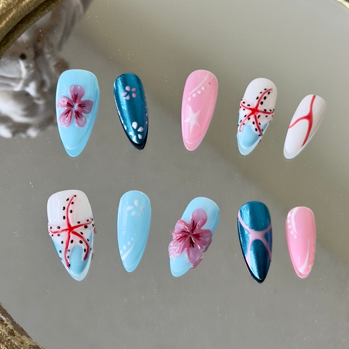 Front view of Seabloom nails showing the mix of blue French tips, pink 3D accents, and intricate linework.