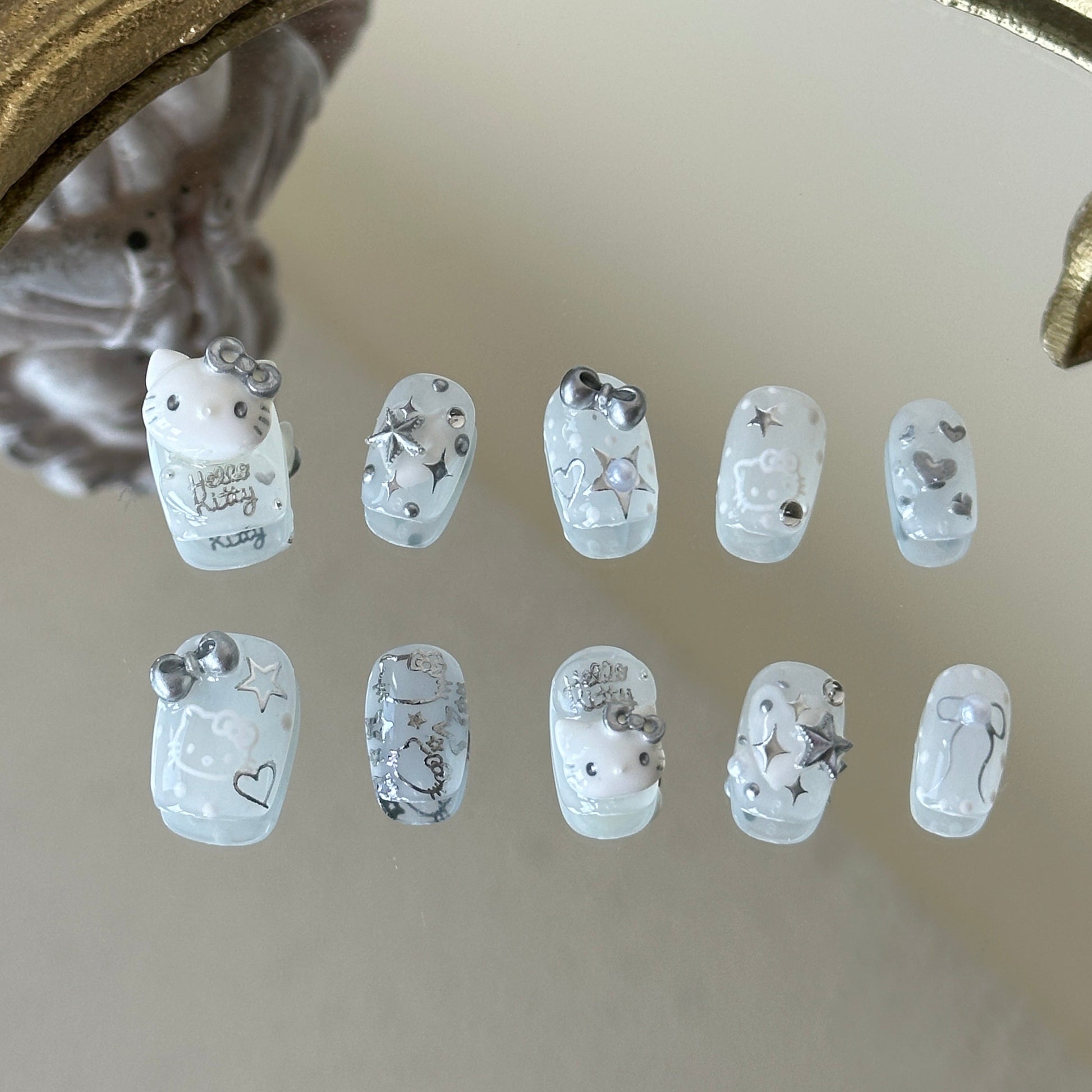 Front view of Silver Kitty handmade nails showing silver chrome stars, hearts, and delicate pearl accents.