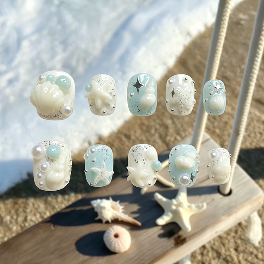 Siren's Treasure press-on nails by MYOB Nails featuring 3D white seashells, starfish, and shimmering sliver glitter.