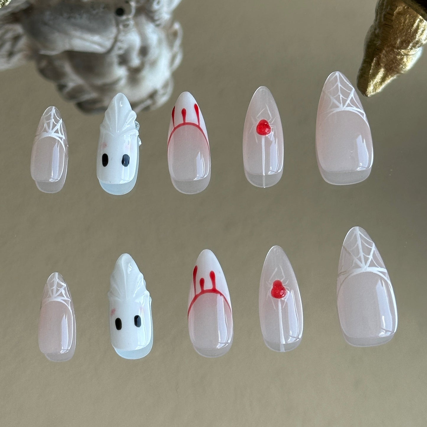 Back view of the Spooky Webs handcrafted nail set by MYOB Nails, showcasing the sharp stiletto shape and ethereal white palette.