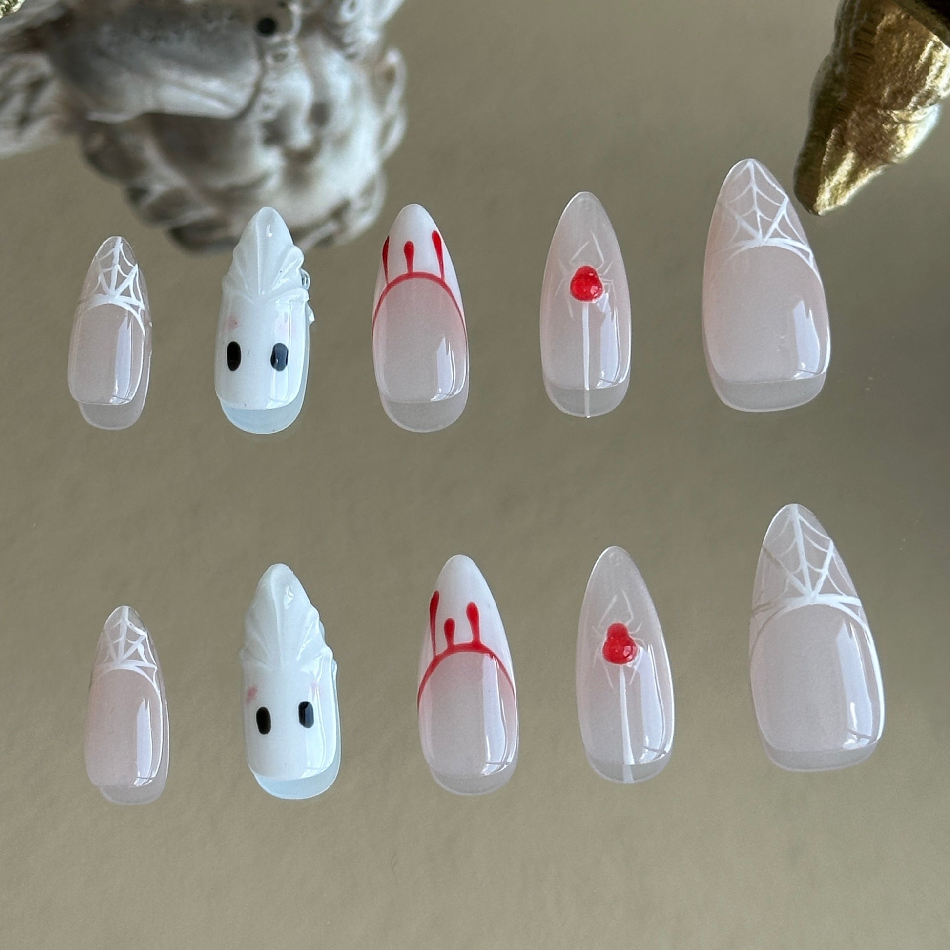 Back view of the Spooky Webs handcrafted nail set by MYOB Nails, showcasing the sharp stiletto shape and ethereal white palette.