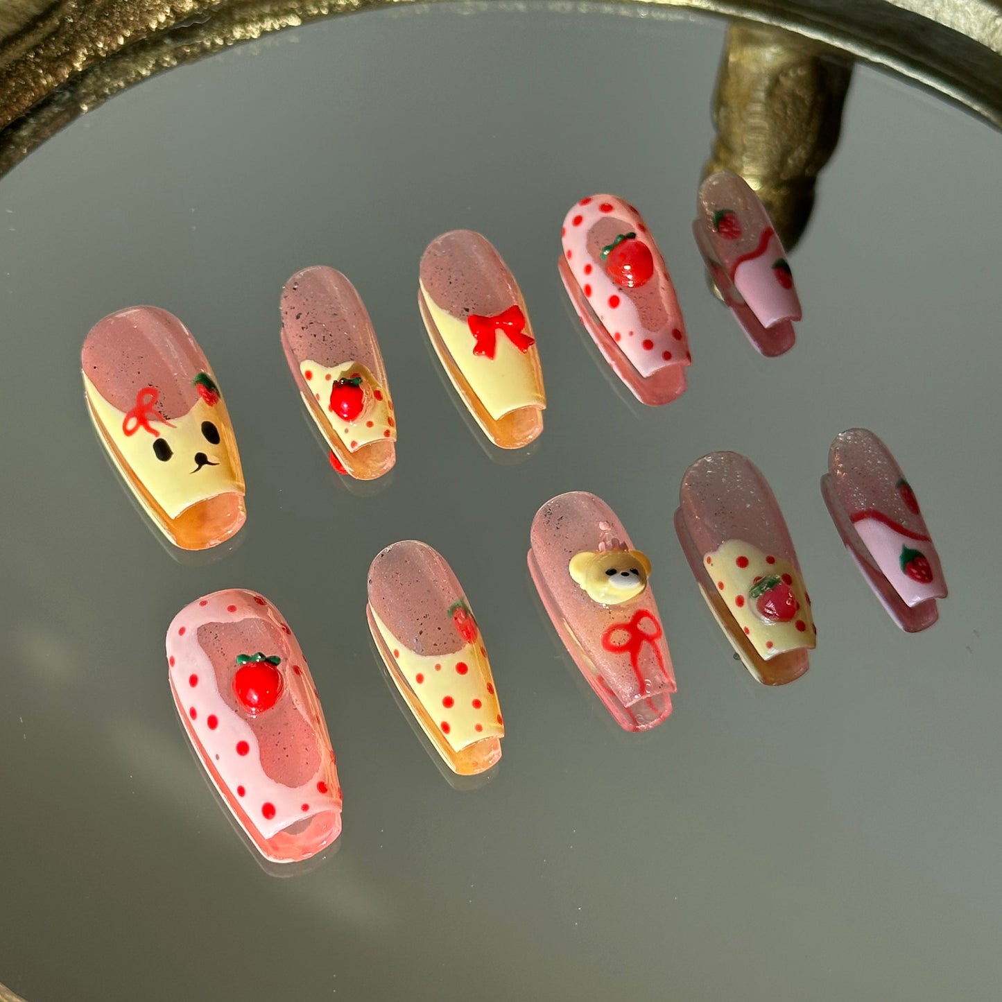 Detailed view of 3D sculpted bears and strawberries combined with hand-painted bow accents by MYOB Nails.