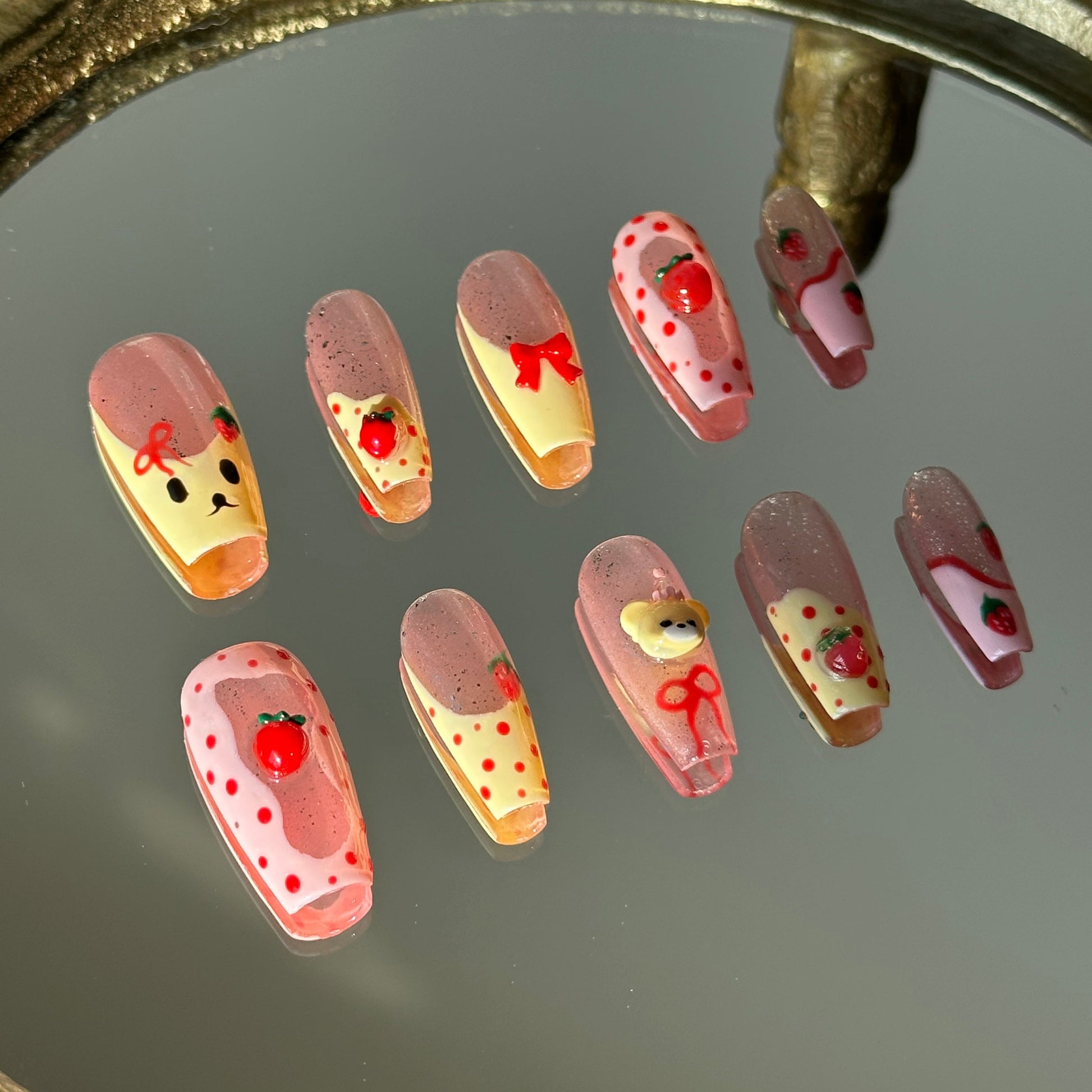 Detailed view of 3D sculpted bears and strawberries combined with hand-painted bow accents by MYOB Nails.