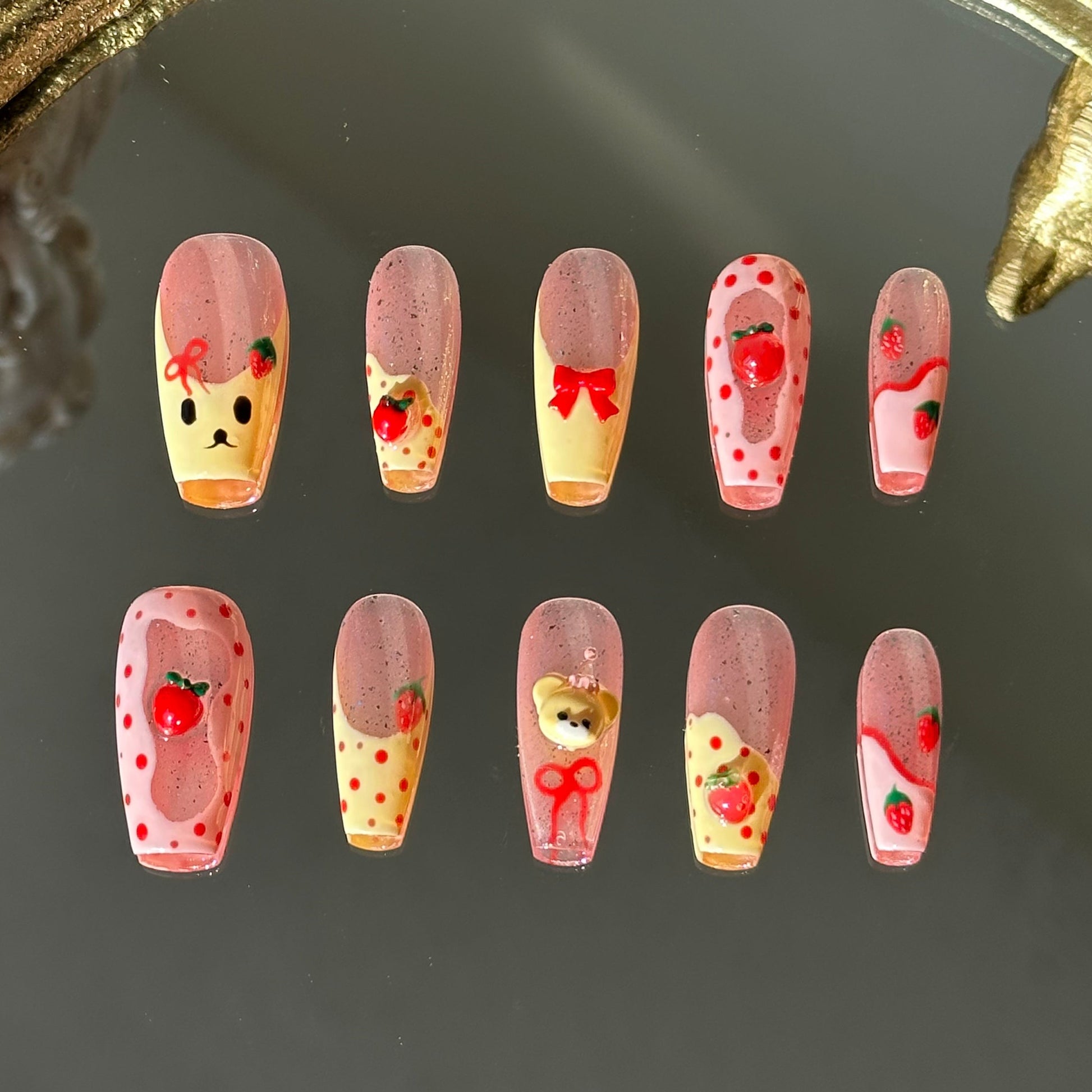 Front view of Strawbeary nails with silver shimmer base, irregular pink borders, and hand-painted cute elements.