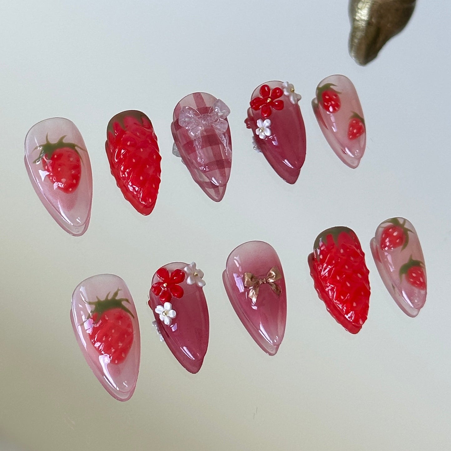 Close-up detail of the 3D sculpted strawberries with glossy protective glaze for a realistic fruit texture by MYOB Nails.