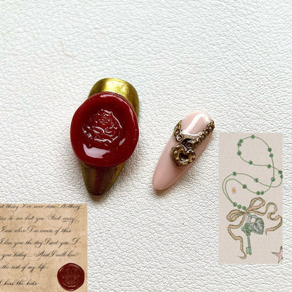 Detailed view of the 3D textures on The Lost Fairytale set, highlighting the realistic red wax seal charm and a luxurious gold-toned heart lock necklace with a metallic chain.