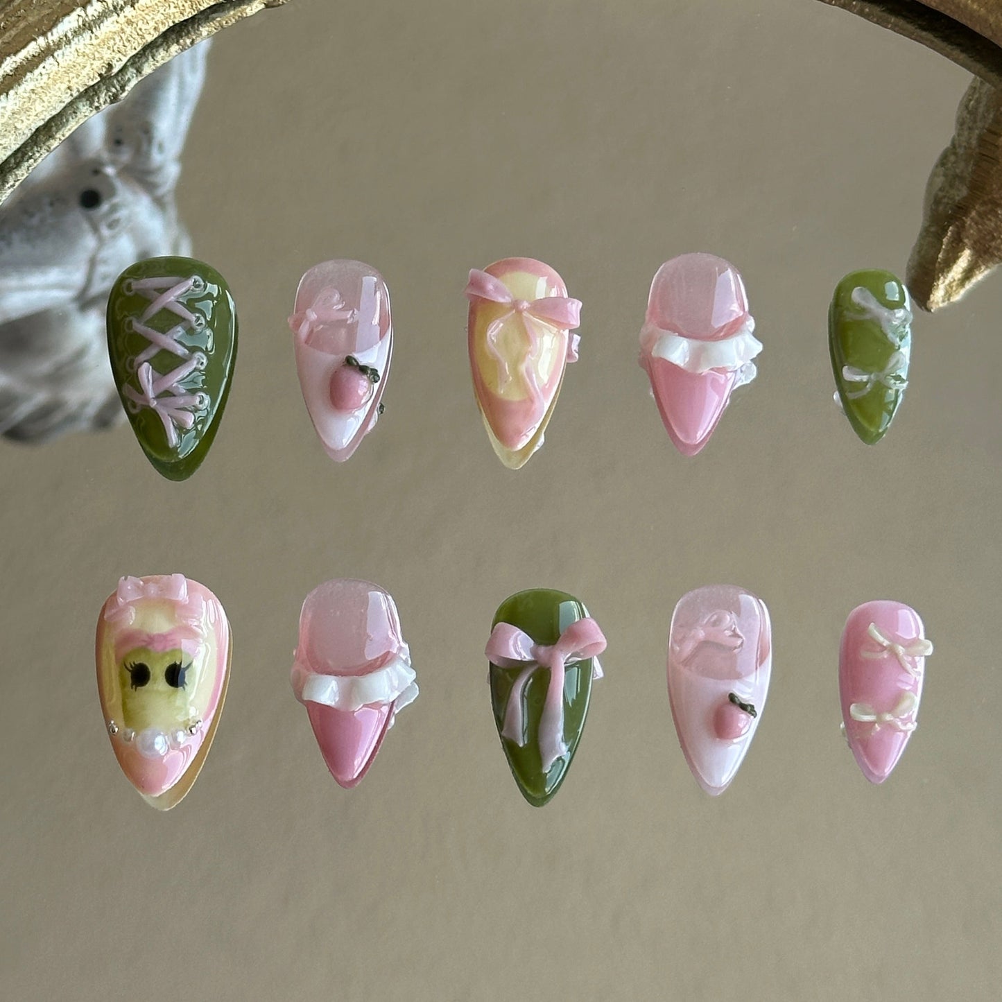 Front view of Tiana handmade press-on nails by MYOB Nails featuring forest green and pink base with 3D bows and corset ribbon art.