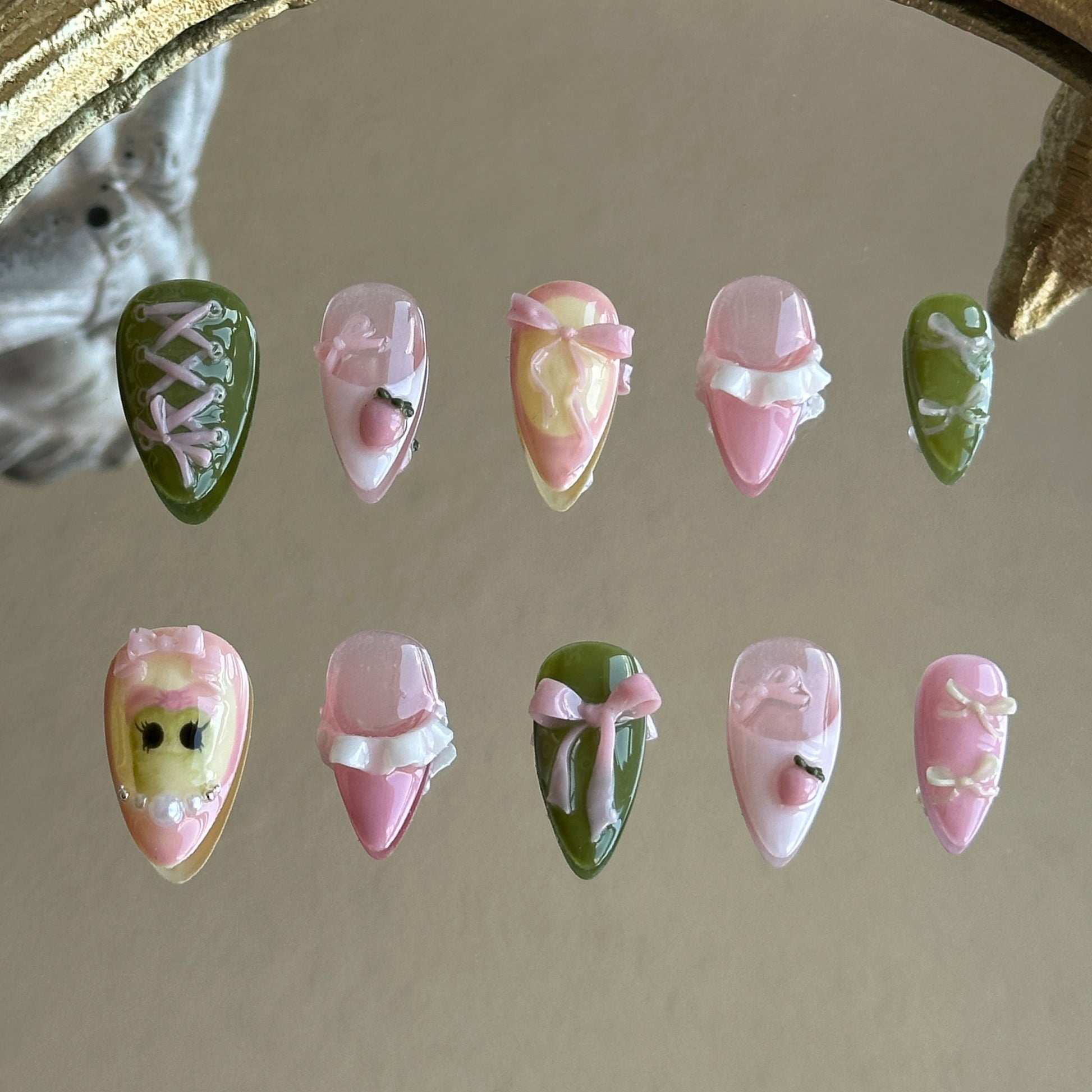 Front view of Tiana handmade press-on nails by MYOB Nails featuring forest green and pink base with 3D bows and corset ribbon art.