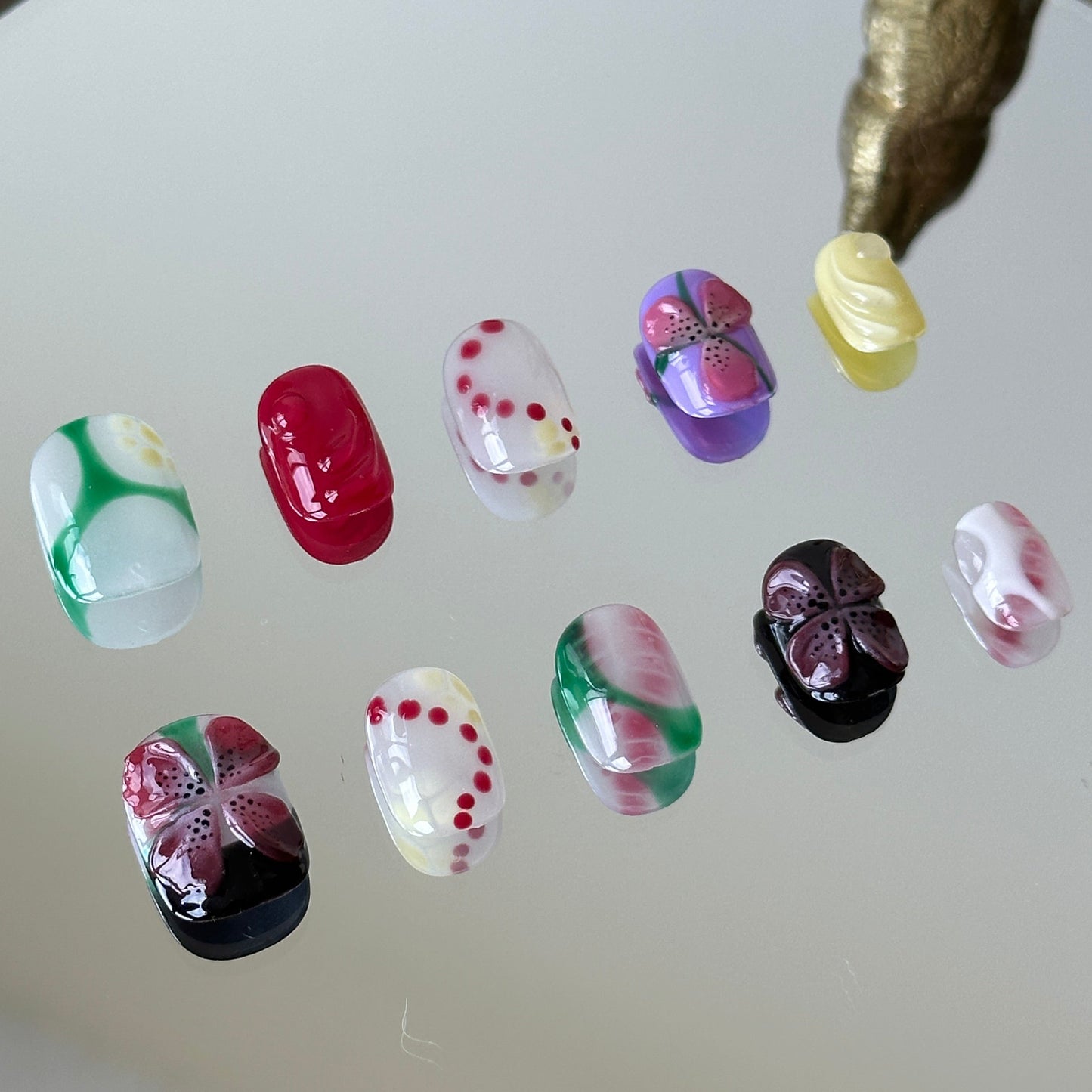 Close-up detail of the vibrant red 3D flower and playful polka dot patterns by MYOB Nails.