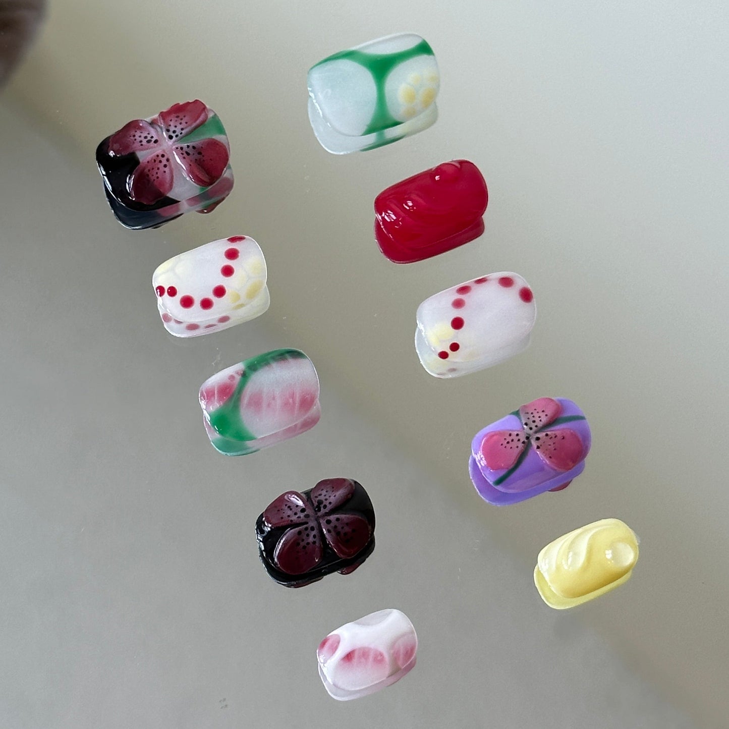 Side view showcasing transparent 3D water drops over green and pink blush ombre bases.