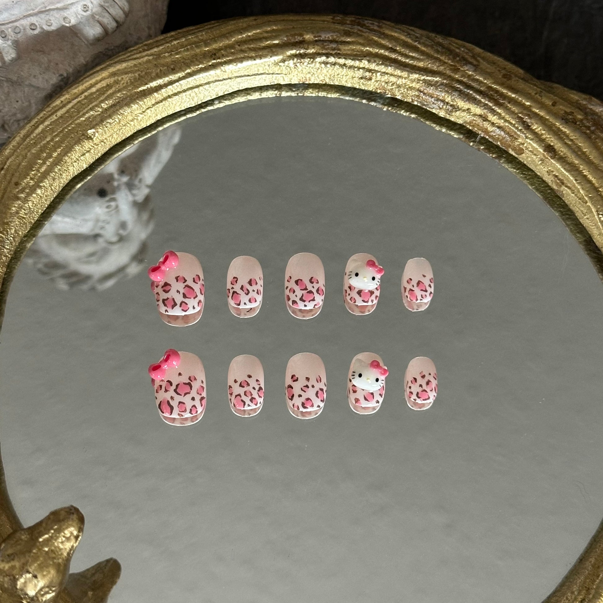 Wild Kitty handcrafted press-on nails by MYOB Nails, featuring pink leopard print and 3D bow charms.