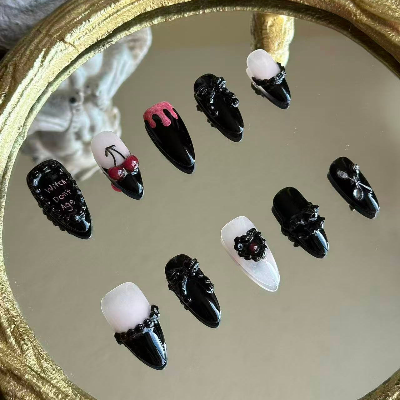 Left side detail of MYOB Nails Witches Don't Age set highlighting the realistic 3D cherry charms and hand-painted gothic lettering.